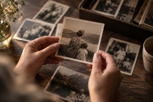 Handen houden een oude familiefoto vast van een oma met haar kleindochter